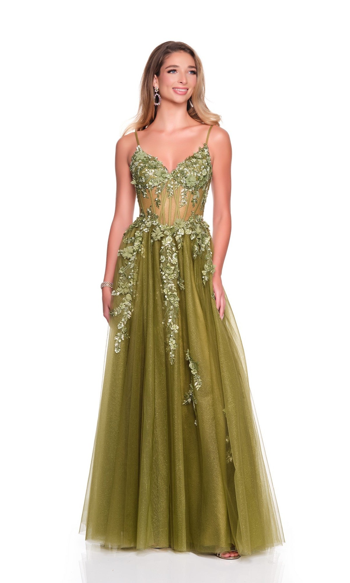 A woman models the Dave and Johnny 12602 long olive green prom dress with floral appliques, a sheer corset bodice, and lace-up open back, standing against a plain white background.